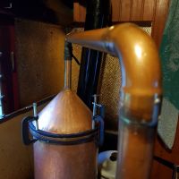 Distillation du géranium rosat (Pelargonium X asperum Ehrhart) dans un alambic en cuivre Distillation du géranium rosat (Pelargonium X asperum Ehrhart) dans un alambic en cuivre